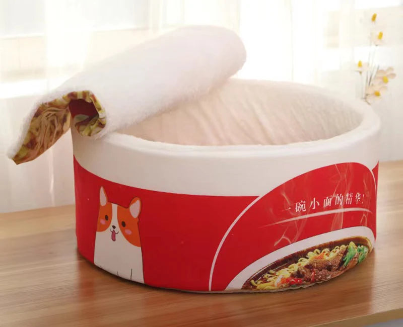 The Instant Noodles Cat Bed by KittyNook features a cozy, circular red design with cartoon cats for premium comfort.