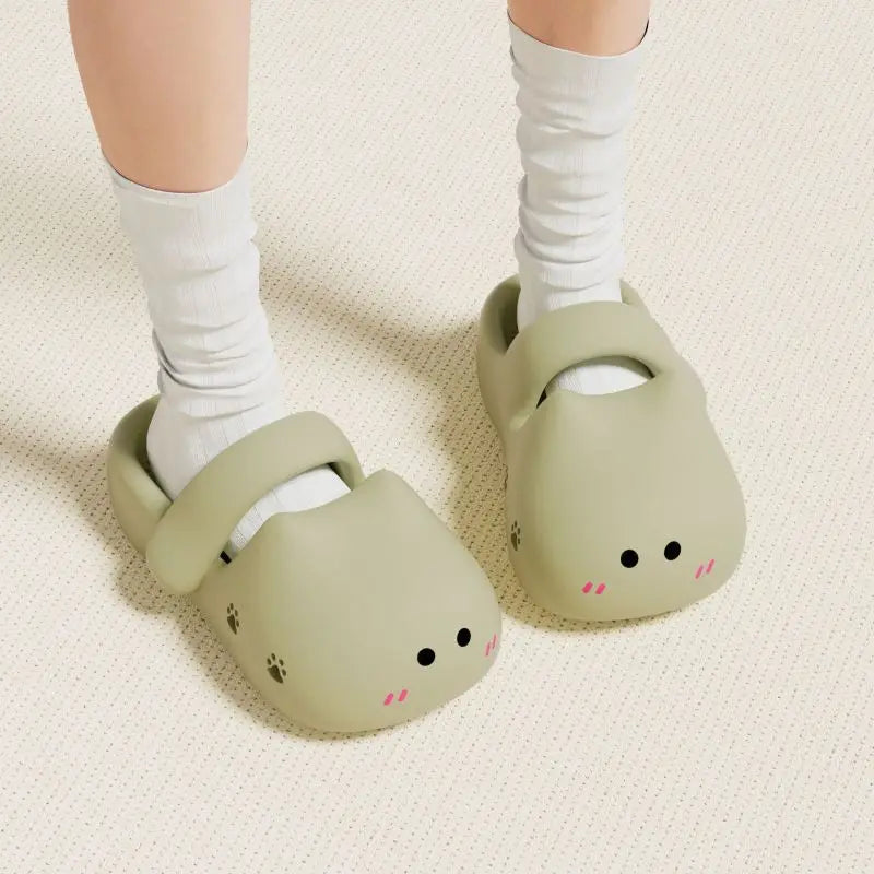 Someone wearing KittyNook Cat Co.’s Adorable Cat Face Comfort Sandals with white socks on a light carpet.