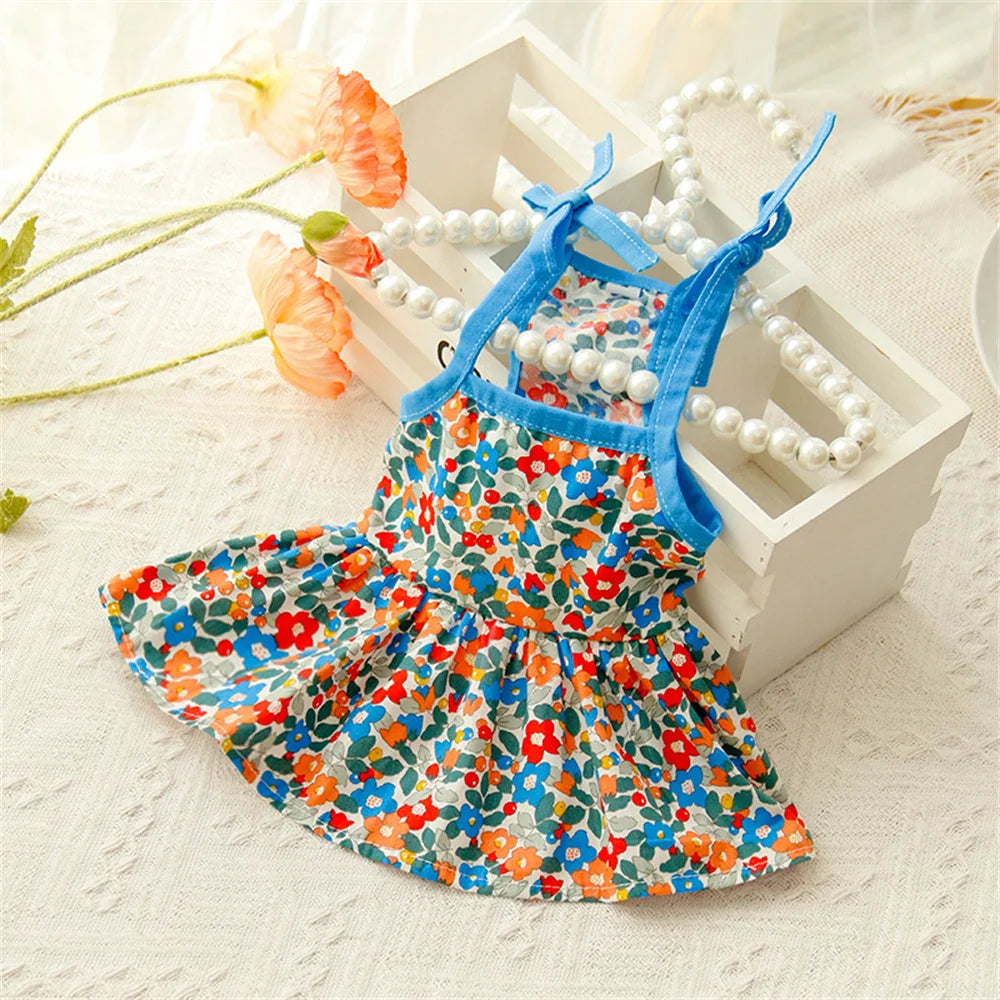 KittyNook Cat Co. Summer Cotton Cat Dress with blue straps, shown on lace near faux pearls and orange flowers.