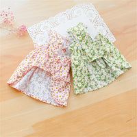 Thumbnail for Two KittyNook Cat Co. Summer Cotton Cat Dresses in pink and green shown on wood with a white doily backdrop.