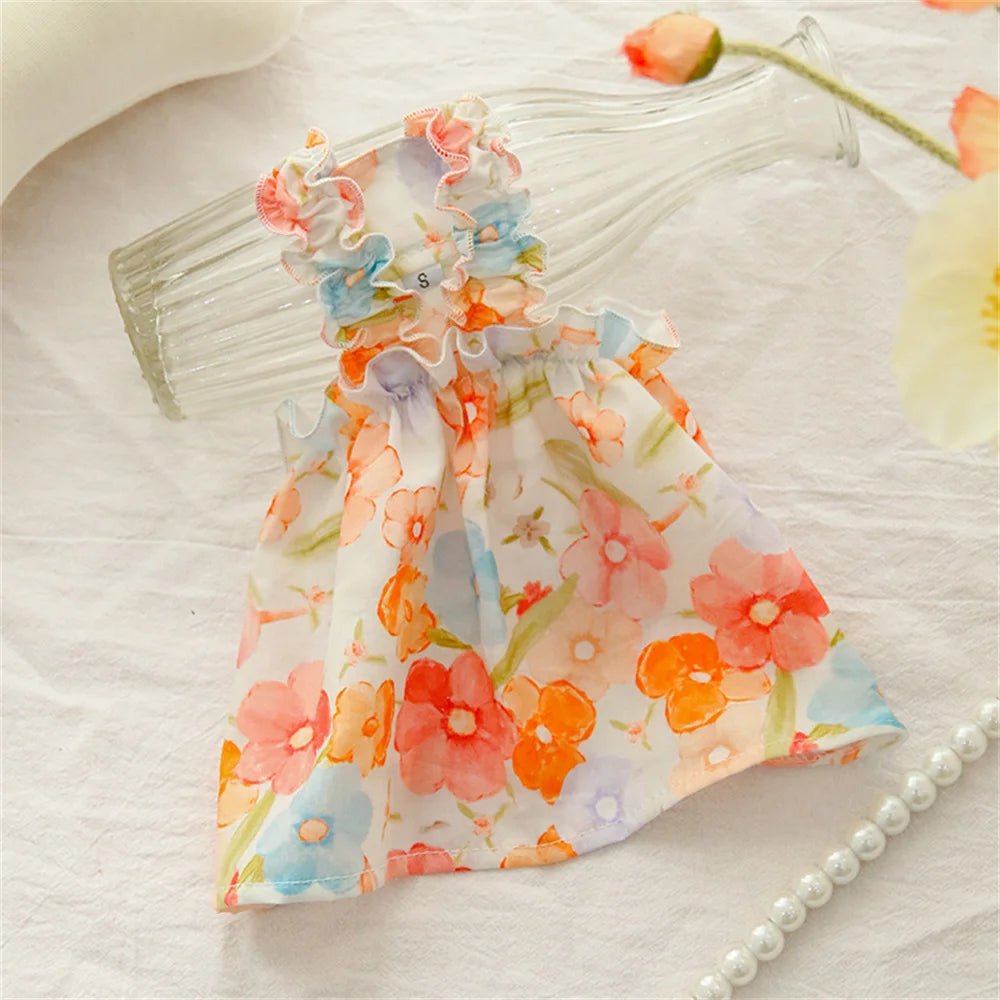 The Summer Cotton Cat Dress by KittyNook Cat Co. is displayed on a glass bottle with flowers and a pearl necklace.