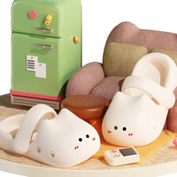 Thumbnail for KittyNook Cat Co. Adorable Cat Face Comfort Sandals with non-slip soles rest by a couch, green fridge, and ottoman.
