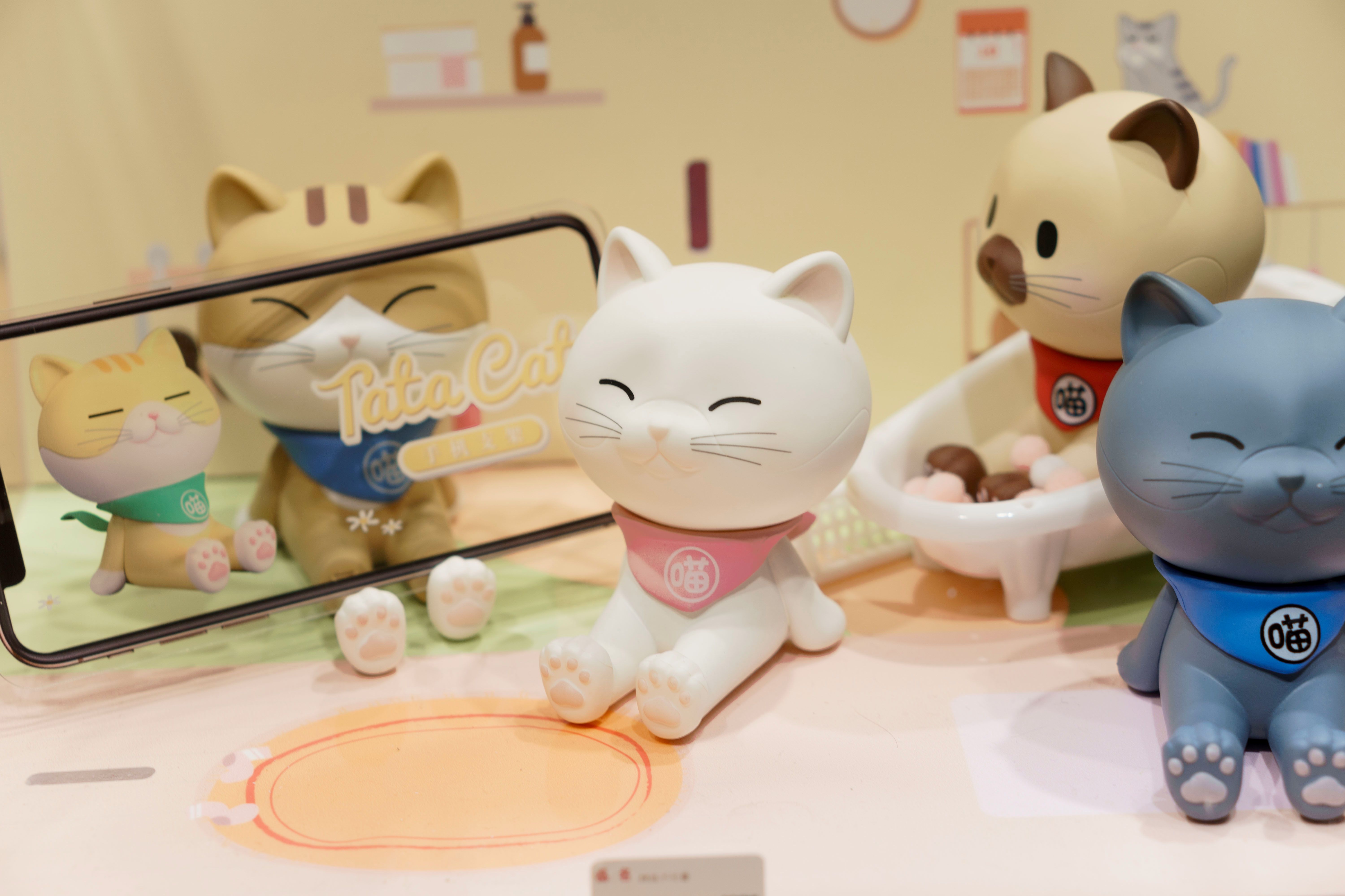 Adorable cat figurines displayed with playful reflections in a mirror | Kitty Nook