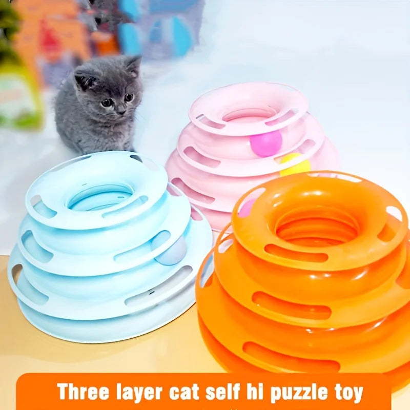 Gray kitten eyes the KittyNook Cat Co. 3-Layer Interactive Cat Toy Tower with Balls: blue, pink, orange on white.
