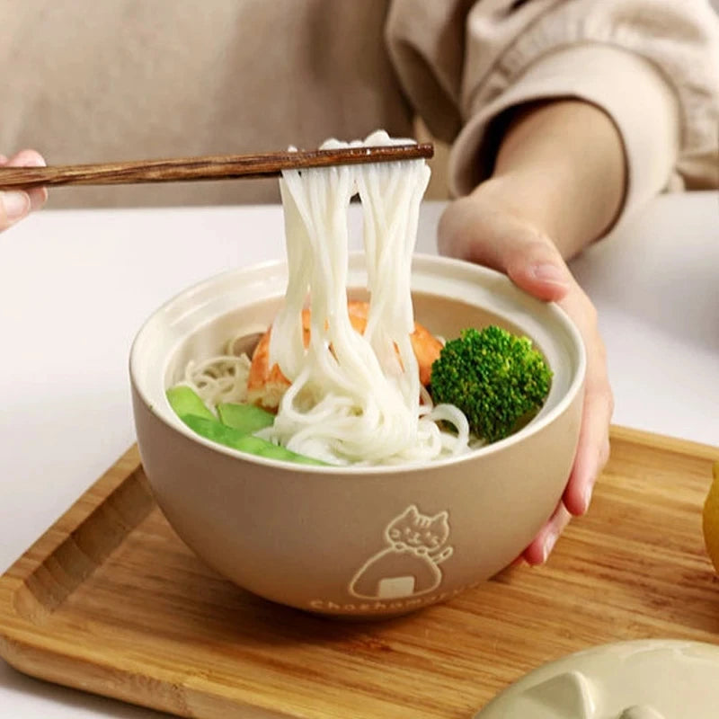 A person lifts noodles with chopsticks from a KittyNook Cat Co. Cute Cartoon Cat Soup Bowl filled with shrimp and veggies.