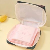 Thumbnail for The KittyNook Cat Co. Cat Pattern Printed Sanitary Napkin Storage Bag holds pink pads, shown on a light yellow surface.