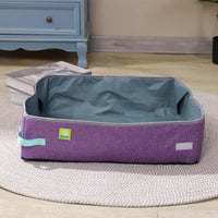 Thumbnail for A purple and gray pet bed is by a blue cabinet with books, near a KittyNook Cat Co. Portable Cat Litter Box.