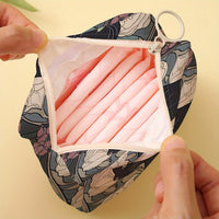 Thumbnail for A hand opens a KittyNook Cat Co. Cat Pattern Printed Sanitary Napkin Storage Bag filled with pink pads.