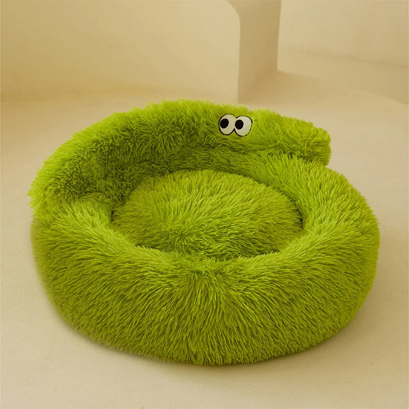 The Warm & Soft Cat Sleeping Pod by KittyNook Cat Co. is a round, green bed with cartoon eyes on cream background.