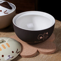 Thumbnail for The Cute Cartoon Cat Soup Bowl by KittyNook Cat Co. sits on a cork mat beside a beige lid with a cat face.