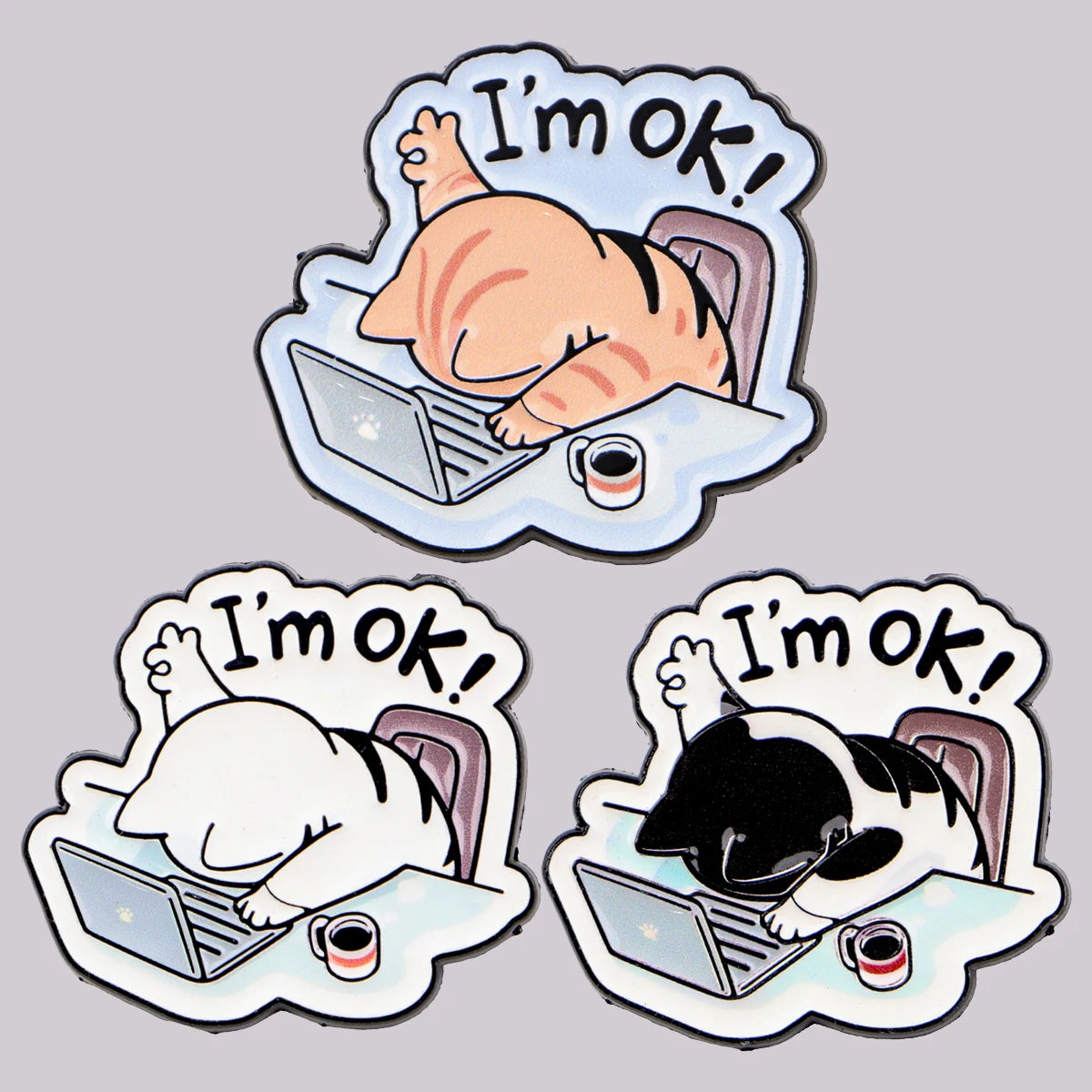Three cartoon cats on laptops with coffee, "I'm OK!" text, each wearing a KittyNook Cat Co. Cat at Work Enamel Brooch Pin.