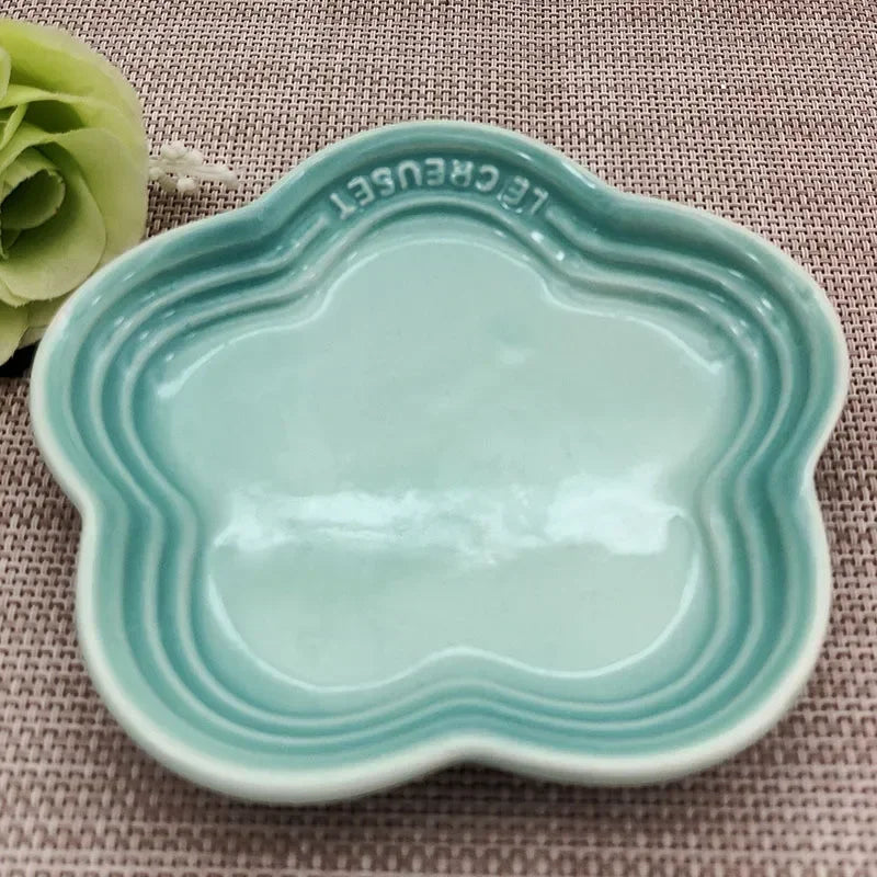 Light blue Extra Wide Raised Flower Cat Bowl by KittyNook Cat Co. on a textured surface, flower-shaped and elevated.