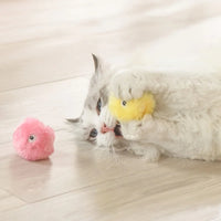Thumbnail for A fluffy white cat plays with the KittyNook Cat Co. Interactive Cat Smart Ball Toy; a pink plush adds extra enrichment.