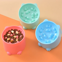 Thumbnail for Three KittyNook Cat Co. Elevated Anti-Choke Slow Feeder Bowls, one with kibble, on an orange and beige surface.