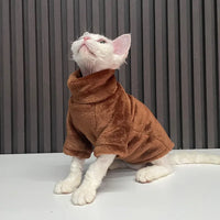 Thumbnail for A white cat models KittyNook Cat Co.'s Warm Winter Hoodies for Hairless Kittens by a dark striped wall.
