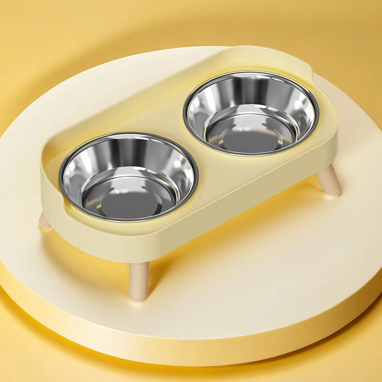 KittyNook Cat Co.'s Dopamine DuoLift Colorful Cat Feeder has stainless steel bowls on a round, light-yellow platform.