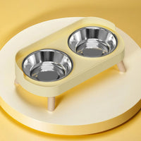 Thumbnail for KittyNook Cat Co.'s Dopamine DuoLift Colorful Cat Feeder has stainless steel bowls on a round, light-yellow platform.