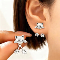 Thumbnail for Woman models KittyNook Cat Co. Vintage Silver Cat Back-Hanging Earrings, holding a matching kitten silhouette earring.