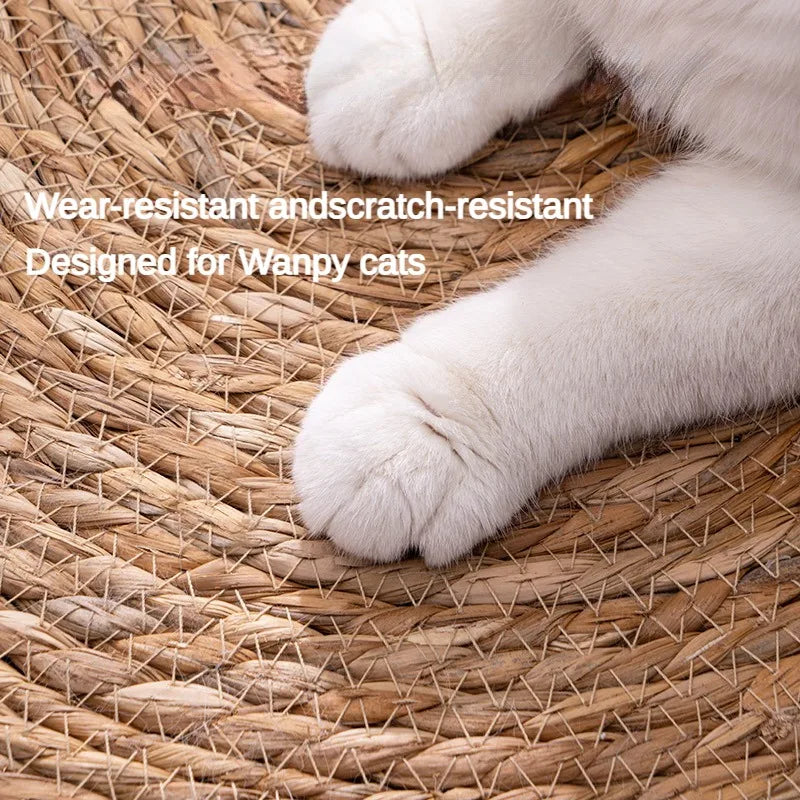 Close-up of a white cat's paws on a woven mat with the KittyNook Cat Co. Natural Rattan Cat Scratcher for happy cats.