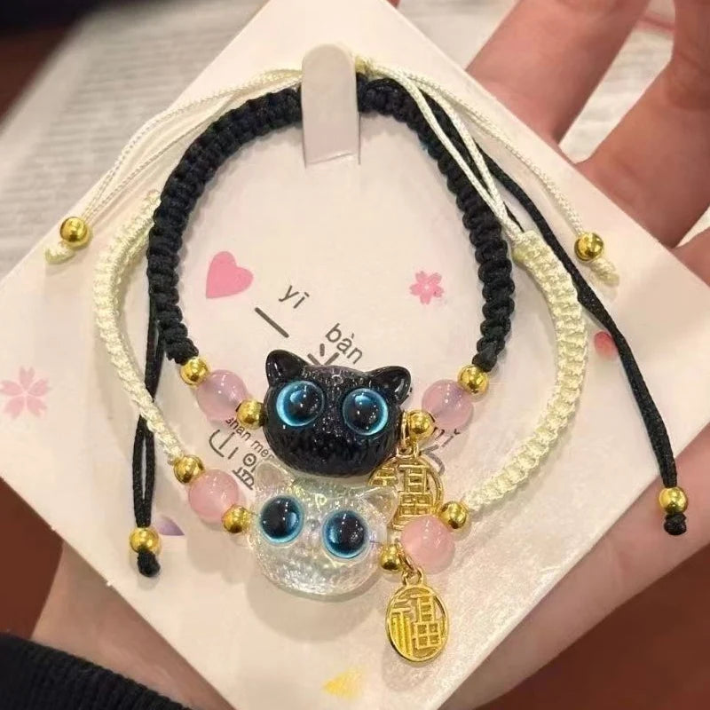 A hand holds two KittyNook Cat Co. Lucky Charm Bracelets for Good Fortune—ideal Pet Parent Gifts on decorative cards.