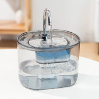 Thumbnail for KittyNook Cat Co. Cat Water Fountain Automatic Filter provides running water for cats, shown on a white table indoors.