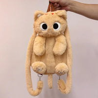 Thumbnail for A hand holds KittyNook Cat Co.'s The Cute Big Eyes Plush Backpack, shaped like a cat with long arms and a tail.