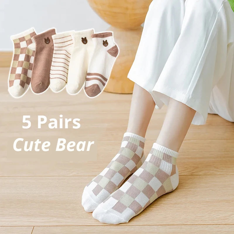 Woman wears checkered socks, with four more pairs of KittyNook Cat Co. Sweet Kitty Pink Short Tube Socks displayed above.