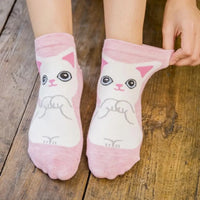 Thumbnail for Wearing KittyNook Cat Co.’s Charming Kitties Women’s Cute Ankle Socks, sitting on a wooden floor and adjusting one.