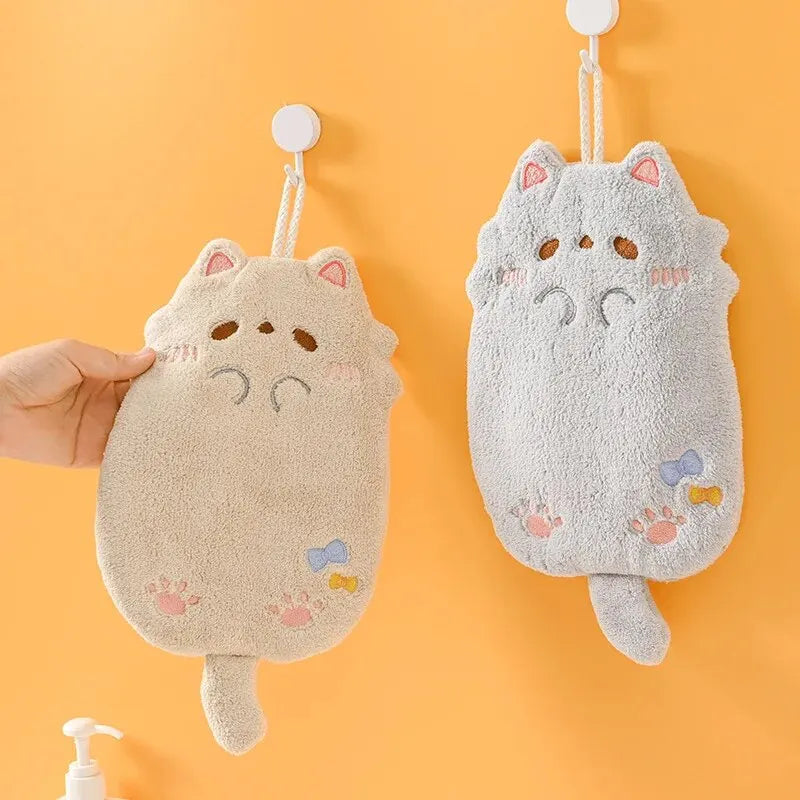 KittyNook Cat Co. Cute Cat Hanging Towels for cat lovers hang on hooks; a hand holds the beige one.