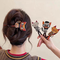 Thumbnail for Woman with hair in a bun wears KittyNook Cat Co.'s Acrylic Cat Hairpin, holding three more cat accessories in hand.