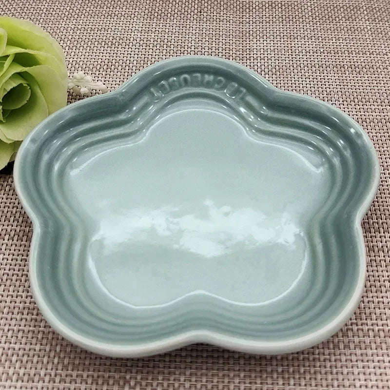 KittyNook Cat Co. Extra Wide Raised Flower Cat Bowl in light blue on a placemat, with a green faux flower nearby.