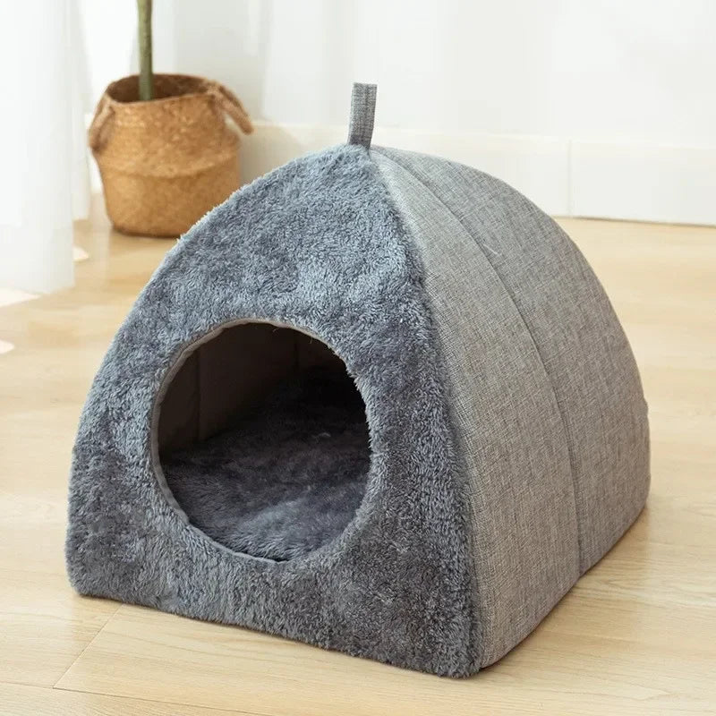 The KittyNook Cat Co. Cozy Triangle Cat Cave Bed has a plush, tent shape with a circular entrance for cats.