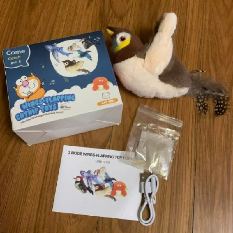 KittyNook Cat Co. Squeaky Plush Cat Toy set: toy, USB cable, user guide & parts bag displayed on a wooden floor.