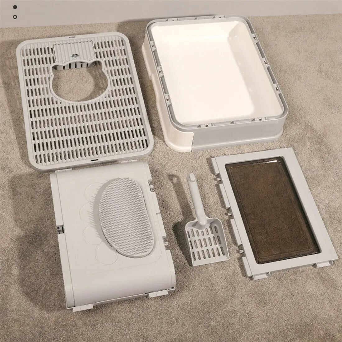 Disassembled Purrfect Foldable Litter Solution with scoop by KittyNook Cat Co. on a beige carpeted floor.