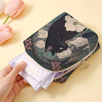 Thumbnail for A hand pulls a pad from the KittyNook Cat Co. Cat Pattern Printed Sanitary Napkin Storage Bag beside pink tulips.