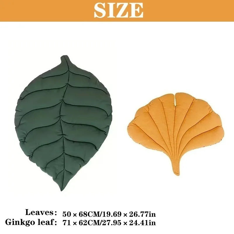 A reversible KittyNook Cat Co. Leaf Pattern Cat Sleeping Mat featuring a green ovate leaf and a yellow ginkgo leaf.