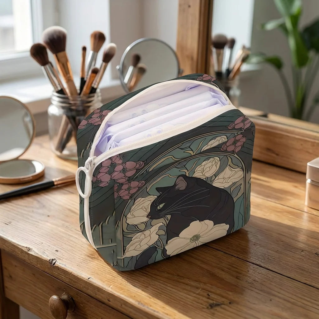 The KittyNook Cat Co. Cat Pattern Printed Sanitary Napkin Storage Bag sits on a vanity with brushes and mirrors.