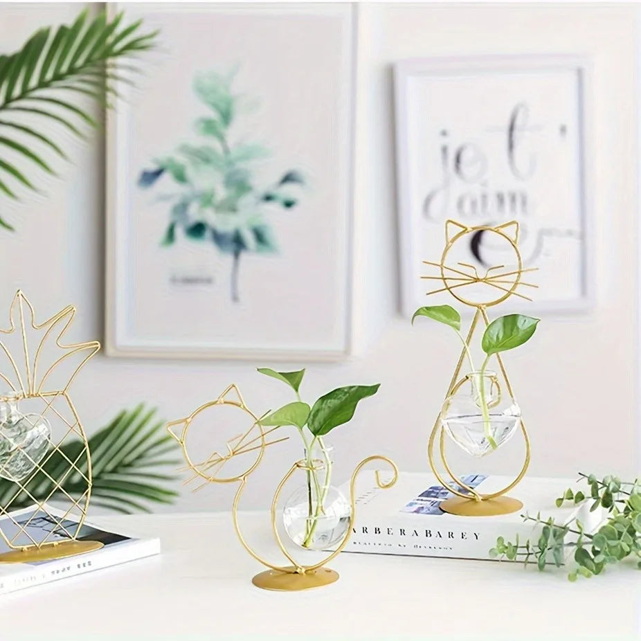 Two KittyNook Cat Co. Modern Cat Iron Hydroponic Decors with green plants on a white table, books and art behind.