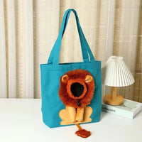Thumbnail for KittyNook Cat Co. Lion Design Soft Cat Carrier Bag—a cute lion face tote, perfect for cats, sits by a lamp and books.