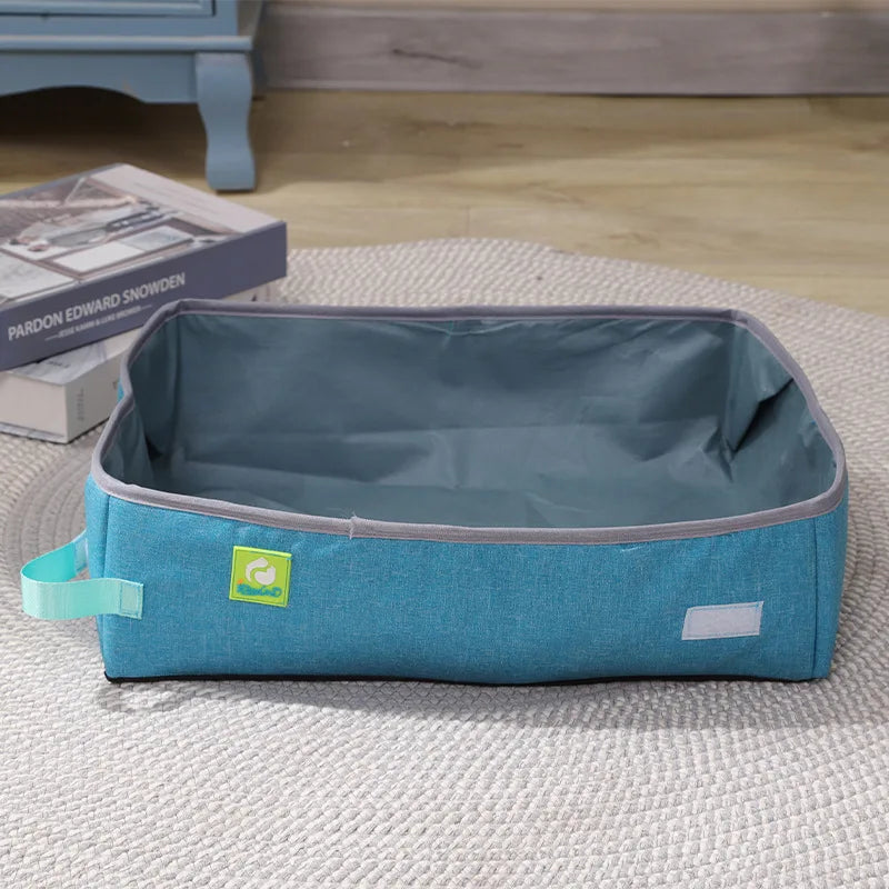 KittyNook Cat Co.'s Portable Cat Litter Box: Travel-Friendly Litter Solution sits on a rug by books and furniture.