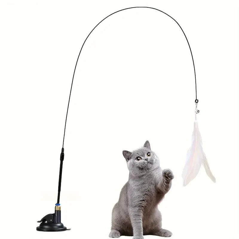 Gray cat plays with KittyNook Cat Co. Ultimate Cat Teaser Toy—feather wand & bell, suction base, on white background.