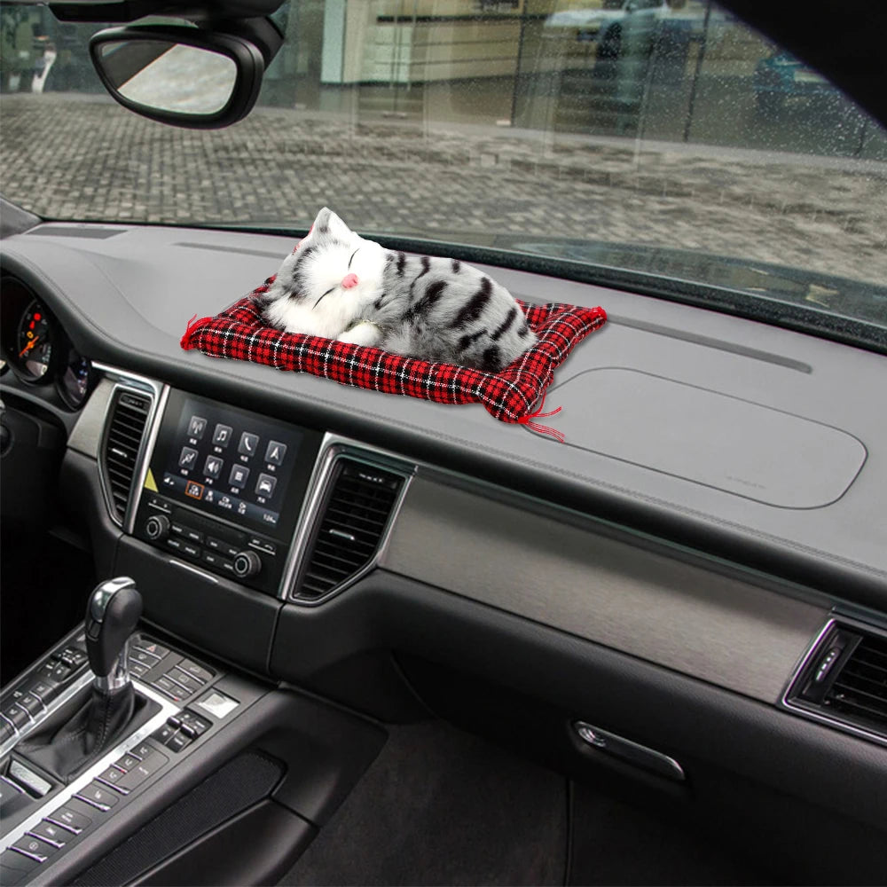 KittyNook Cat Co.’s Sleepy Kitten Plush Decoration naps on a plaid pillow—cute for your car dashboard and city drives.