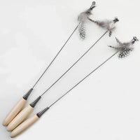 Thumbnail for Three KittyNook Cat Co. Eco-Friendly Wood & Feather Cat Teasers with beige handles and feathers on black rods.