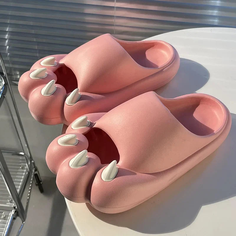 KittyNook Cat Co. Comfy Outdoor Cat Slippers with kawaii cat faces and white claws, shown on a sunlit round table.