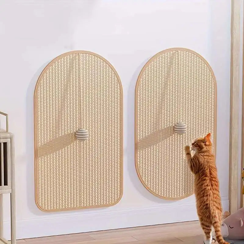 A ginger cat scratches the KittyNook Cat Co. Durable Sisal Cat Scratch Pad with a ball, mounted on a white wall.
