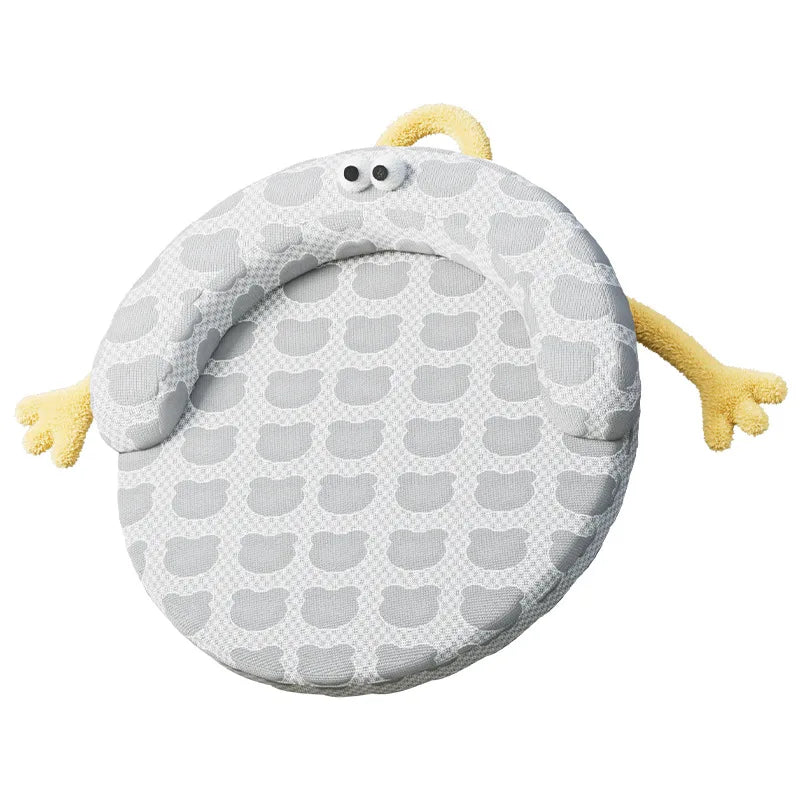 The KittyNook Cat Co. Ice Silk Cat Nest is a round, gray baby lounger with yellow arms and cute black-and-white eyes.