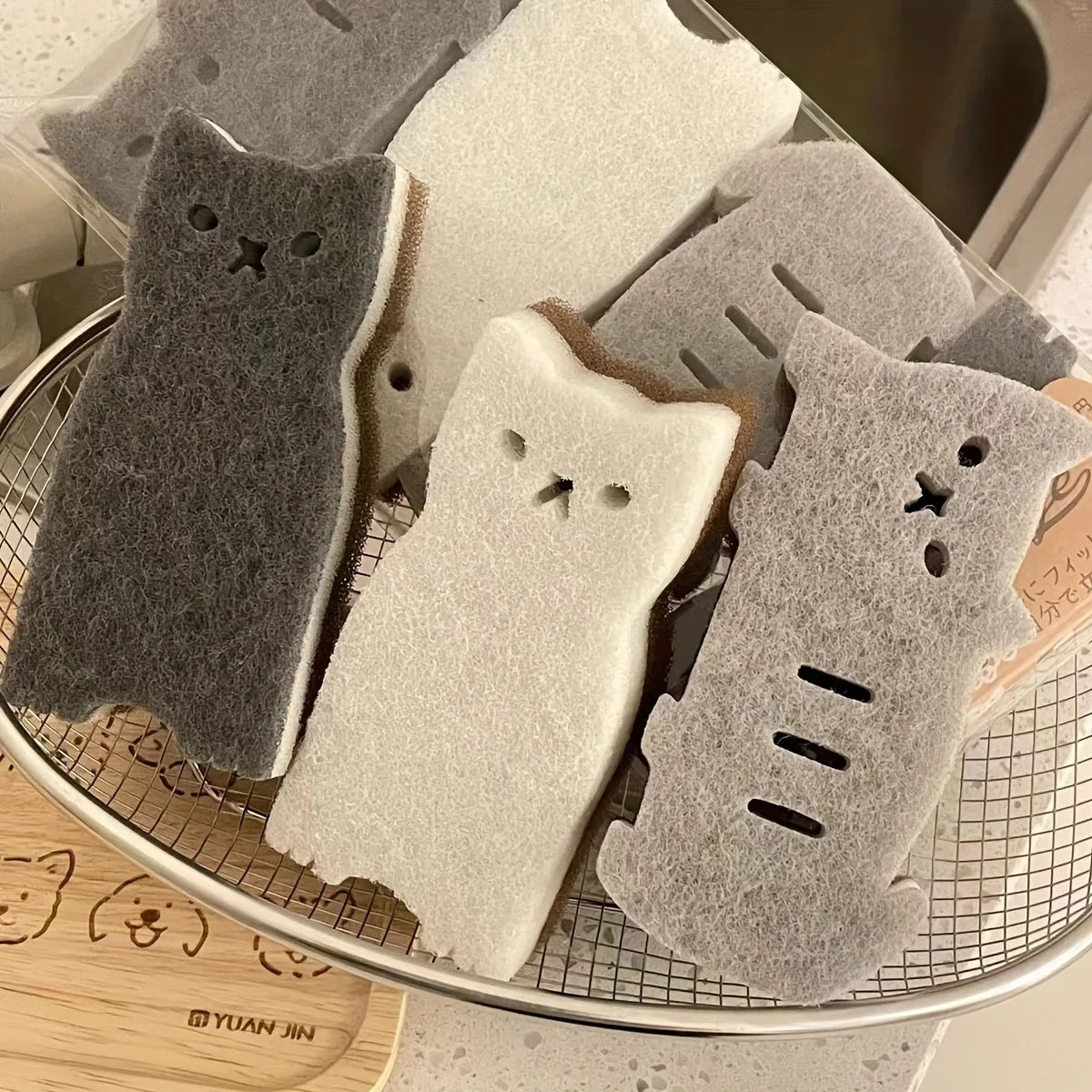 A drying rack holds KittyNook Cat Co.'s Adorable Cat-Shaped Dish Sponge Set – 4 pieces—in white, gray, and black.