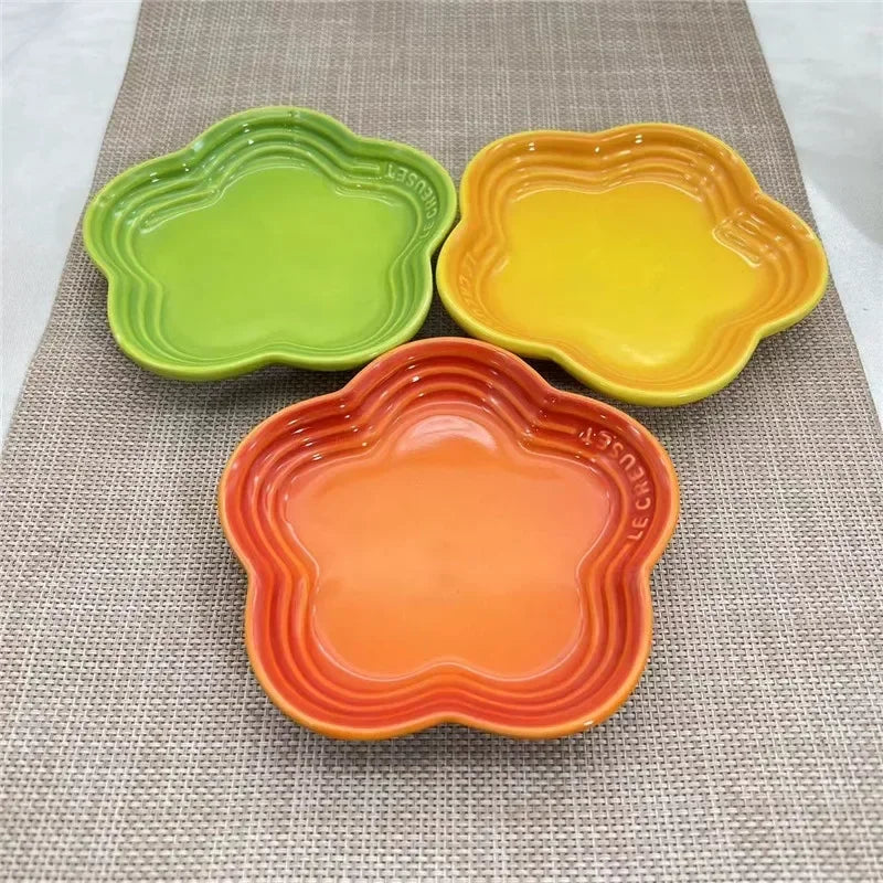Three KittyNook Cat Co. Extra Wide Raised Flower Cat Bowls sit on a beige textured mat.
