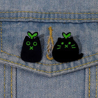 Thumbnail for Two KittyNook Cat Co. Black Cat Enamel Brooches with green sprouts add cute flair to any denim jacket for cat lovers.