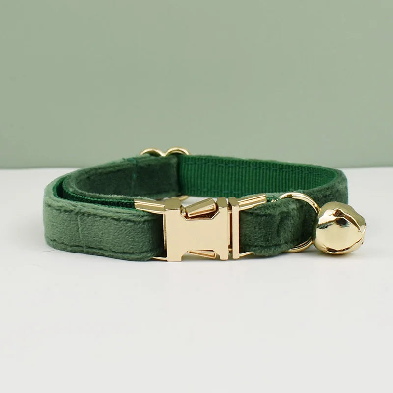 KittyNook Cat Co. Velvet Cat Collar features a gold buckle and bell for comfort and style, shown on a green backdrop.